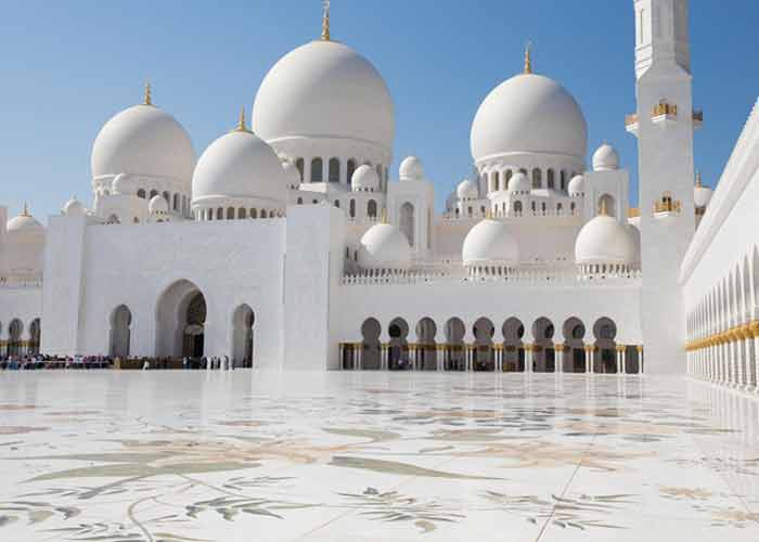 Vue extrieure de la grande mosque Sheikh Zayed  Abu Dhabi avec ses dmes blancs et sa cour orne de motifs floraux