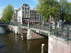 Vue sur le canal d'Amsterdam, un pont et des maisons typiques