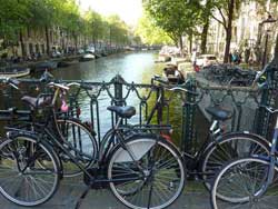 Plusieurs vélos noirs sur un pont d'Amsterdam