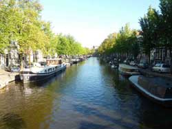 Vue sur le canal dans le centre historique d'Amsterdam avec des péniches amarrées