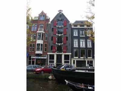 Maison historique grise avec des volets rouges et un pignon triangulaire, Amsterdam, Pays-Bas