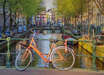 Vélo orange sur un pont à Amsterdam