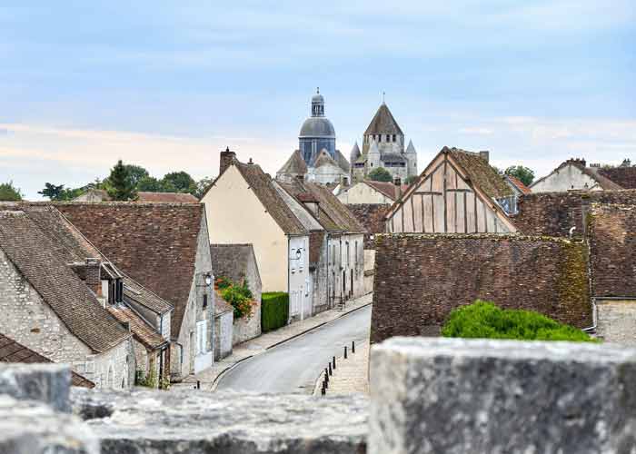 Vue panoramique sur la cité médiévale de Provins, avec ses maisons en pierre
et à colombages, ses toits en tuiles et la collégiale Saint-Quiriace en arrière-plan, illustrant le patrimoine historique classé à l’UNESCO