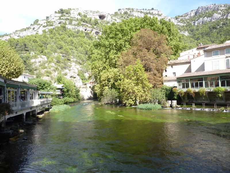 Panorama de la Sorgue traversant Fontaine-de-Vaucluse, au pied des falaises calcaires du Vaucluse