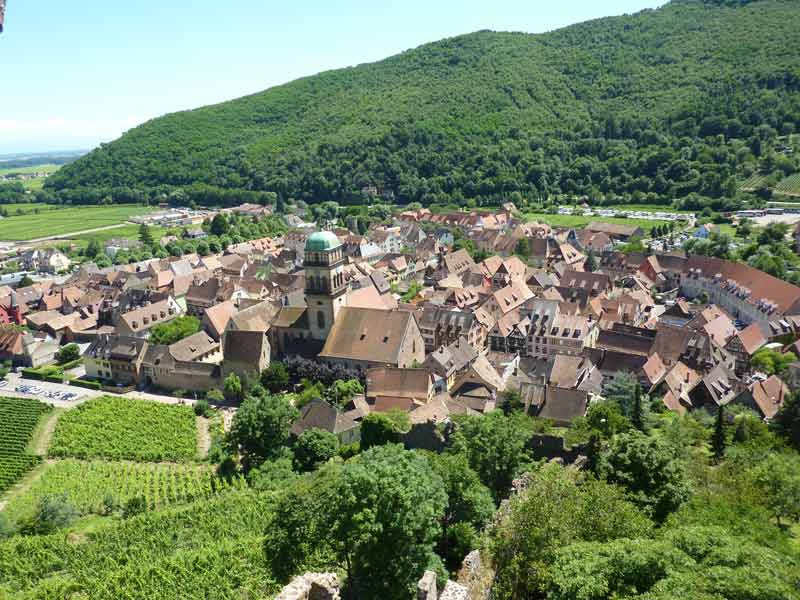 Vue panoramique sur le village de Kaysersberg entouré de vignes et de collines verdoyantes