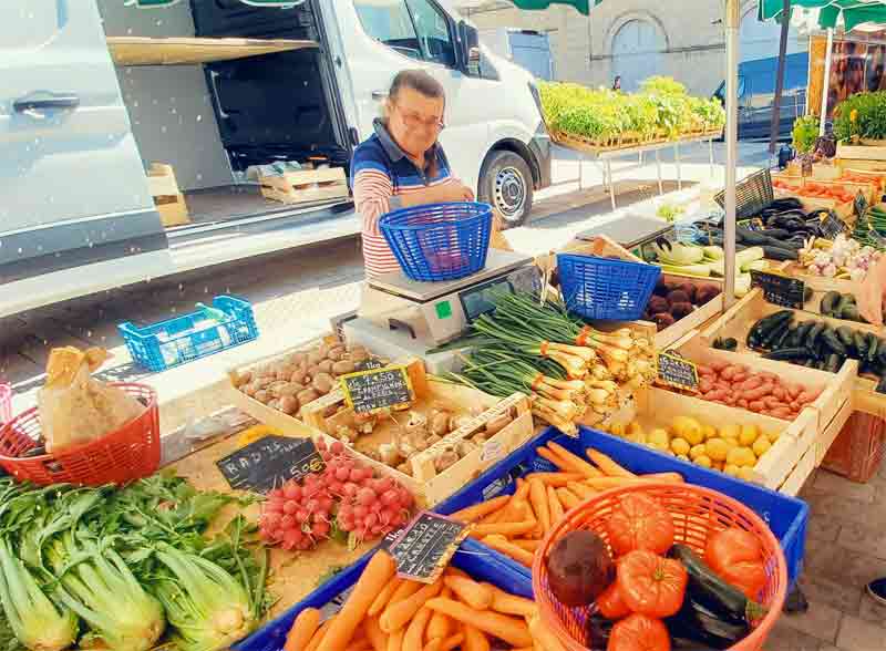Marché local près d’un camping dans le sud ouest, étals de légumes frais et ambiance conviviale