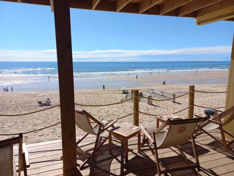 Terrasse en bois avec transats face à l’océan, dans un camping du Sud-Ouest en accès direct à la plage