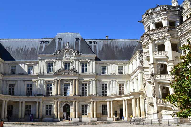 Cour intérieure du château de Blois avec ses façades Renaissance et classique, et l’escalier monumental à vis sur la droite