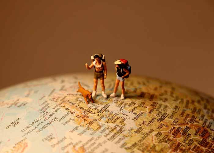 2 figurines sur un globe terrestre