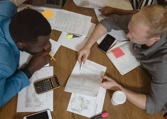 Runion de travail autour de documents et d'un ordinateur pour organiser des dplacements professionnels