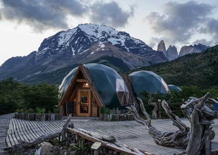 D�mes de glamping align�s au pied d'un massif montagneux au cr�puscule