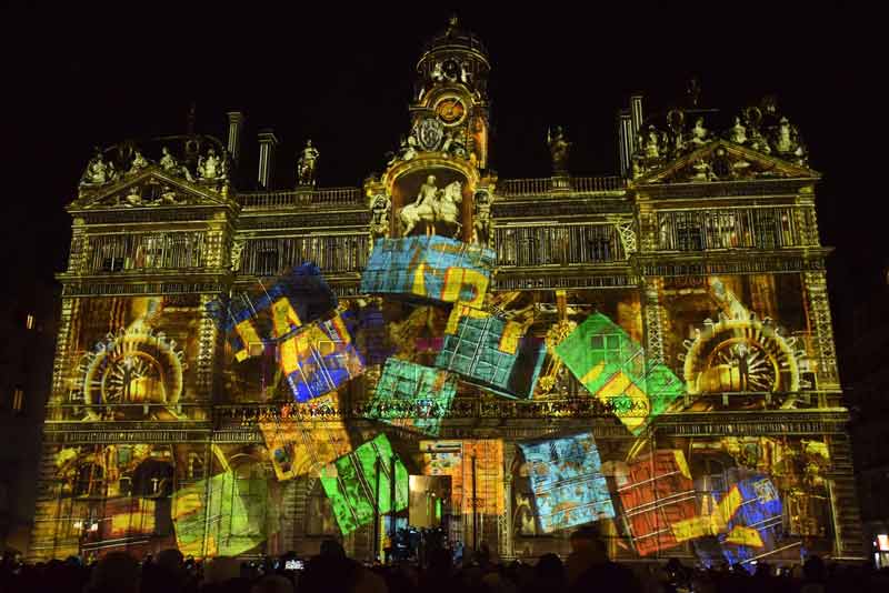 Projection lumineuse colorée sur la façade de l’hôtel de ville de Lyon, place des Terreaux, pendant la Fête des Lumières, un week-end en décembre