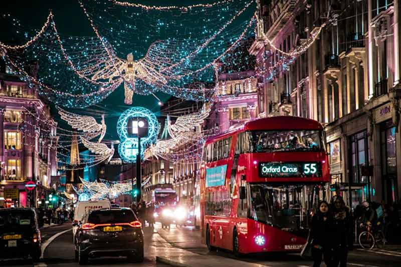 Anges lumineux de Noël au-dessus de Regent Street à Londres, avec un bus rouge à impériale en direction d’Oxford Circus, pour un week-end en décembre
