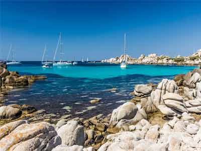 bateaux qui transportent des touristes pour un bapteme de plongée dans les eaux turquoise des îles Lavezzi en Corse