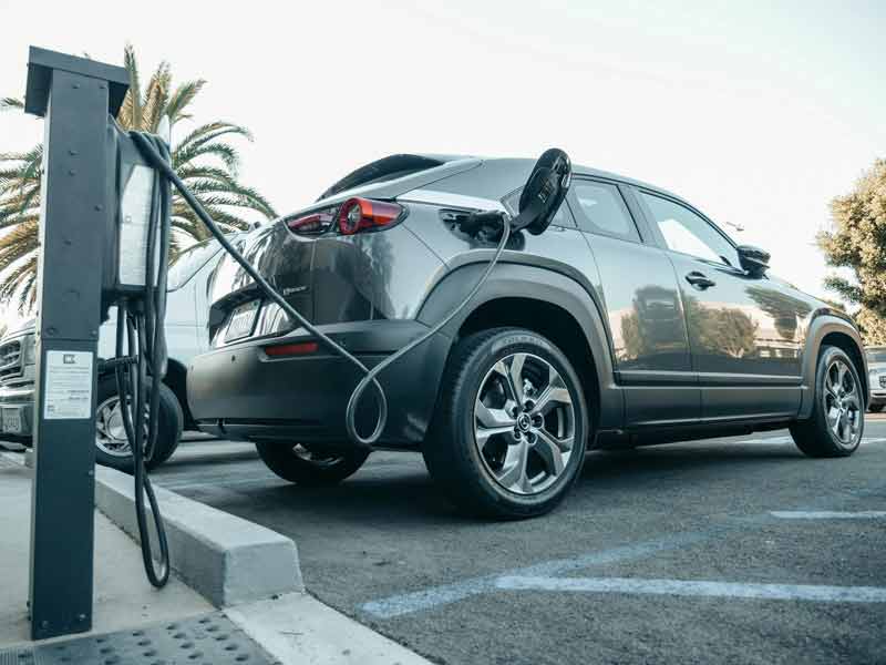 Voiture électrique en cours de recharge sur une borne publique lors d’un week-end de voyage