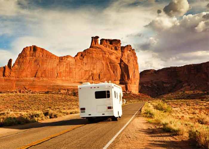 Camping-car sur une route du Grand Canyon National Park en Arizona, face aux formations rocheuses rouges