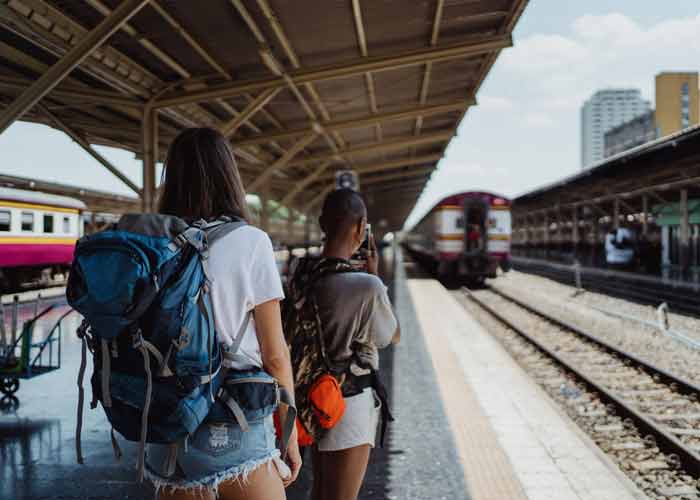 Deux voyageuses, sac � dos sur les �paules, sur le quai d�une gare au moment o� un train arrive, pour un week-end en Europe en train