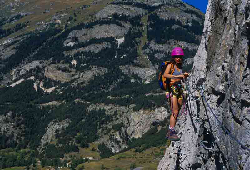 Pratiquer la via ferrata sur une paroi rocheuse en montagne, une activité à sensations fortes entre randonnée et
escalade