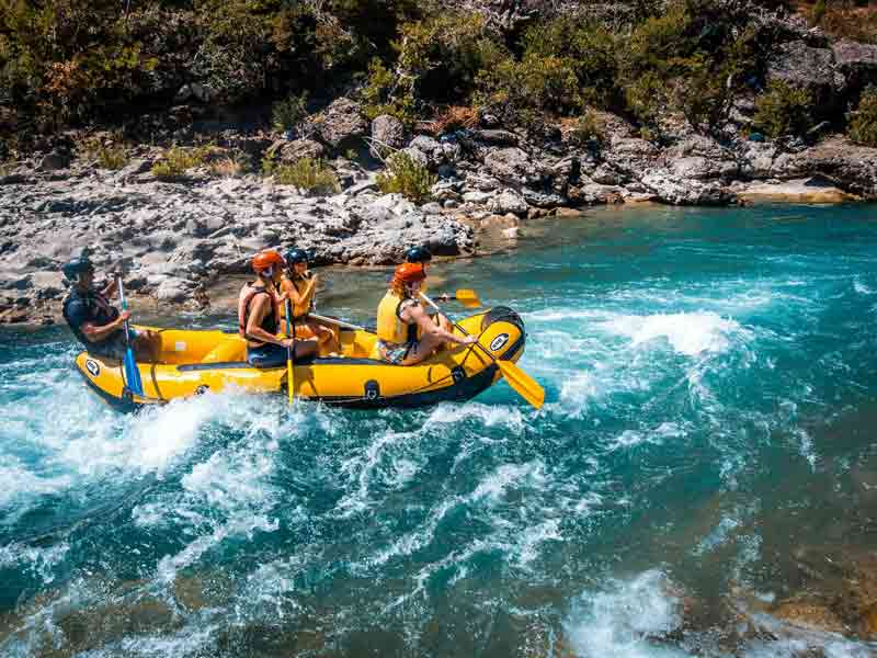 Équipe en rafting sur une rivière agitée, une activité à sensations fortes idéale pour un week-end aventure