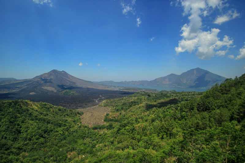 Vue panoramique sur le mont Batur et le lac Batur à Bali, avec ses pentes volcaniques et la végétation verdoyante environnante