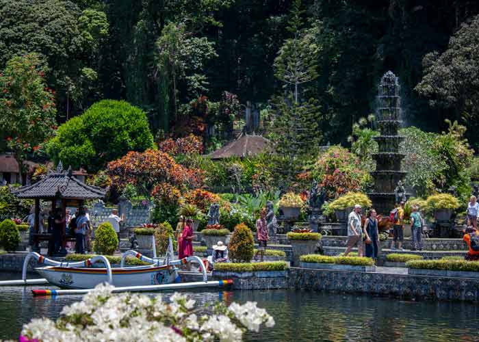 Jardins aquatiques de Tirta Gangga  Bali, avec ses bassins, statues, vgtation tropicale et visiteurs se promenant autour des fontaines