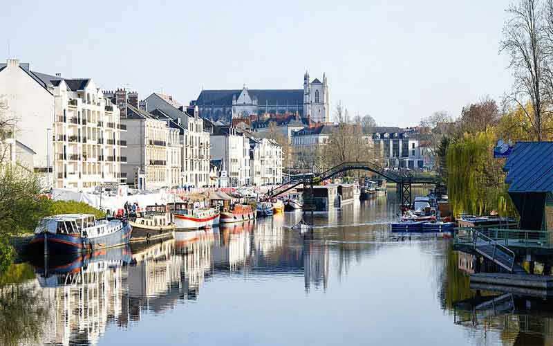 Vue sur des bateaux amarrés le long de l'Erdre et sur la passerelle Barbusse reliant la capitainerie de l'île de Versailles au quai Henri Barbusse