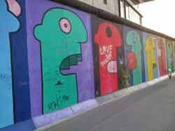 Peinture de Thierry Noir sur la East Side Gallery (mur de Berlin) représentant des visages de toutes les couleurs