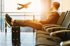 voyageur qui regarde un avion décoller depuis la salle d'embarquement d'un aéroport