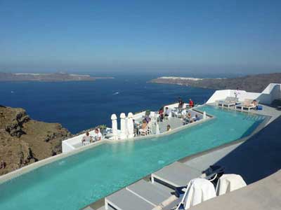 Vue sur une piscine à débordement et sur la mer depuis l'île de Santorin (Grèce)