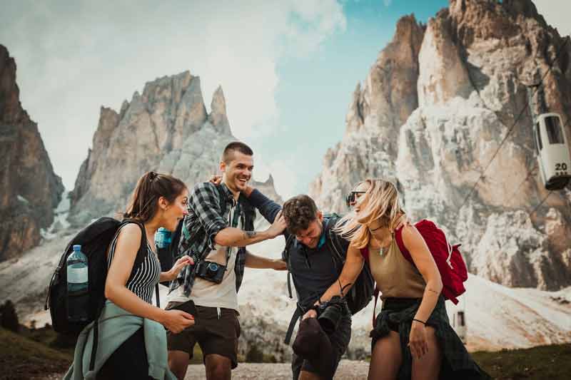 Groupe de jeunes en voyage organisé qui rient à la montagne