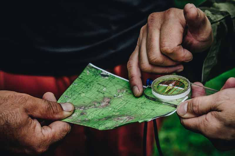 Voyageur qui utilise une boussole pour se repérer lors de vacances à l’étranger