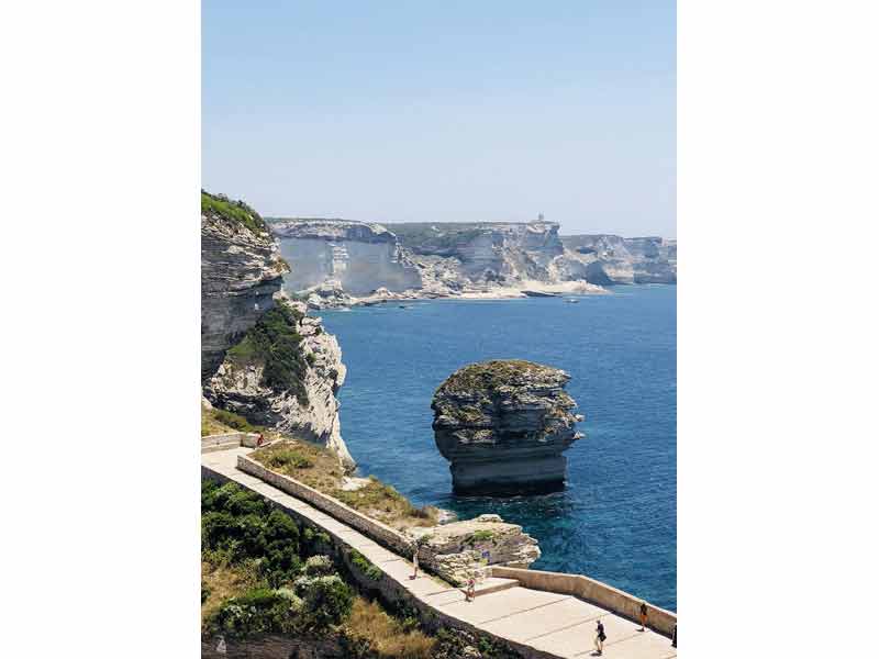 Le rocher du grain de sable à Bonifacio, Corse, émergeant des eaux turquoise de la Méditerranée, avec les falaises blanches en arrière-plan