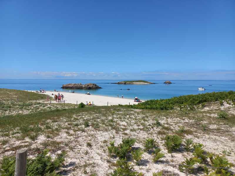 Plage de sable blanc et eaux turquoise des îles Glénan, un incontournable pour une excursion en bateau depuis la côte bretonne