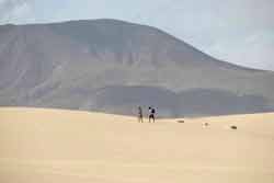 Touristes qui marchent dans le désert de Fuerteventura (Espagne, Europe)