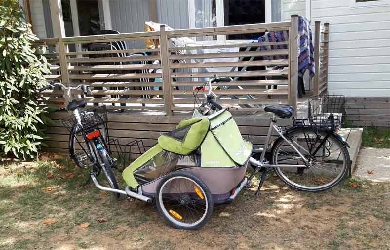 Vélo avec remorque enfant stationné dans un camping sur l’île de Ré, parfait pour explorer l’île à vélo en famille