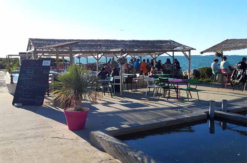 Terrasse en bord de mer sur l’île de Ré, ambiance décontractée pour un apéritif face à l’océan au coucher du soleil