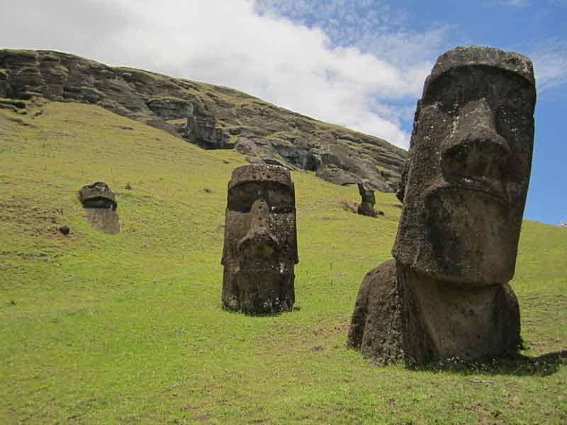 Statues moaï de l’île de Pâques dressées sur une colline verdoyante, vestiges d’une civilisation polynésienne mystérieuse au cœur du Pacifique