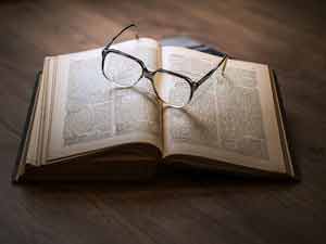 Dictionnaire ouvert avec une paire de lunettes pose dessus