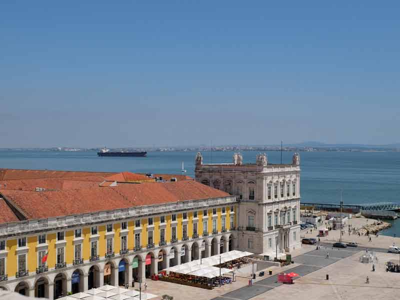 Vue sur les arcades de la place du Commerce de Lisbonne et sur le bâtiment abritant le centre d’interprétation de l’histoire de la morue