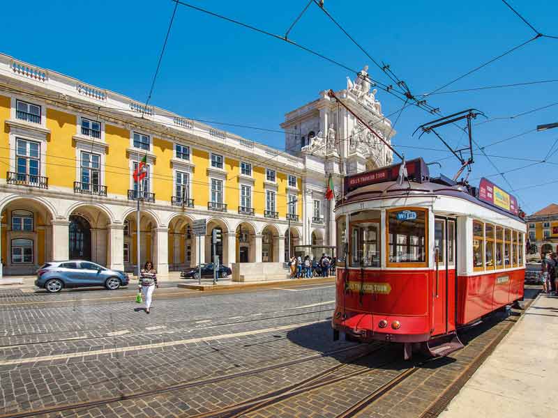 Vue sur le ministère de la justice et sur un tramway rouge (eléctricos) depuis la place du commerce à Lisbonne (Portugal)