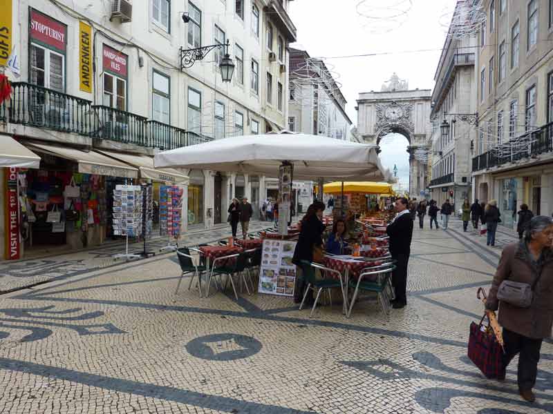 Commerçants dans la rua Augusta avec vue sur le sol revêtu de petits pavés blancs et noirs représentant des mosaïques