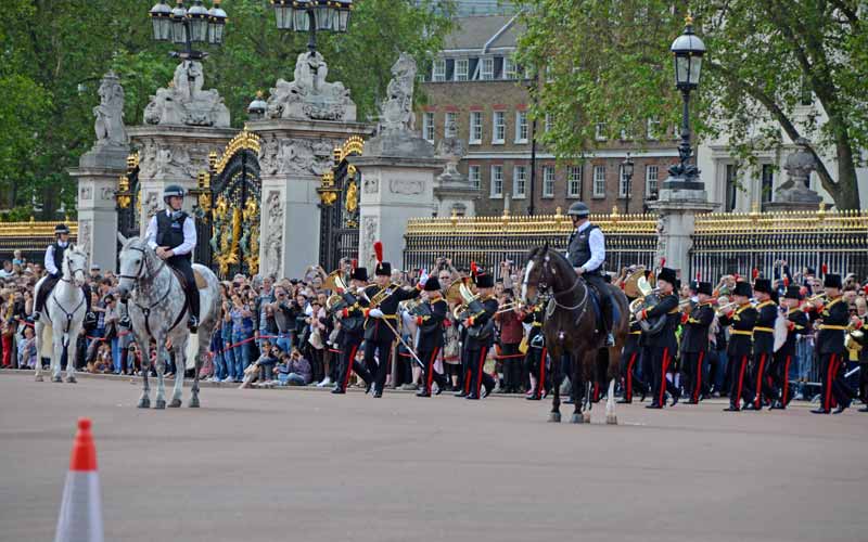 Des touristes attendent la relève de la garde devant le palais.