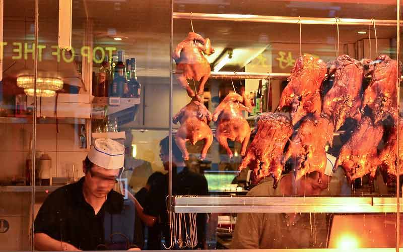 Cuisinier chinois en train de préparer un plat à base de poulet