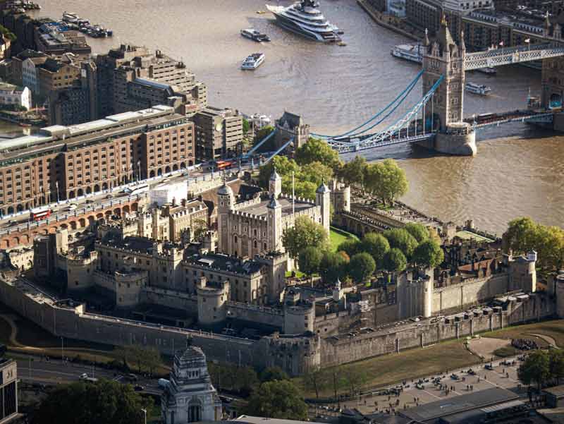 Vue aérienne de la Tower of London au bord de la Tamise, avec le Tower Bridge en arrière-plan