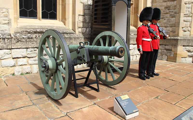 Gardes royaux de la Tour de Londres à côté d'un canon