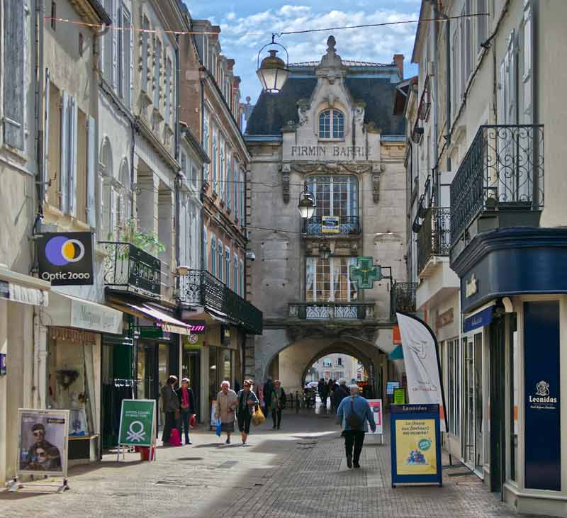 Rue de Paris à Villeneuve-sur-Lot avec la porte Firmin Barrie et ses commerces animés