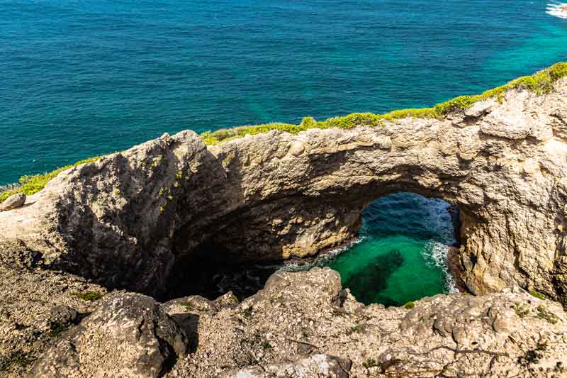 Gueule Grand Gouffre à Marie-Galante, arche naturelle creusée dans la falaise dominant une eau turquoise des Caraïbes