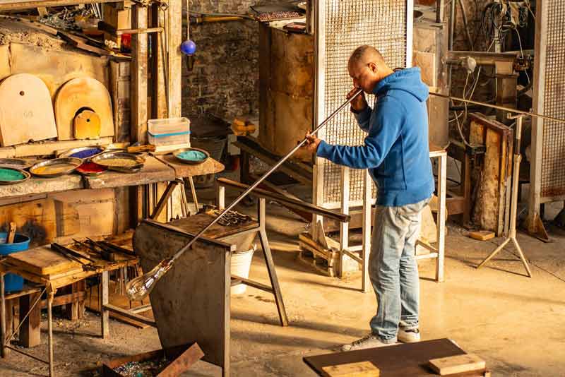 Artisan souffleur de verre à Murano en plein travail dans un atelier traditionnel à Venis