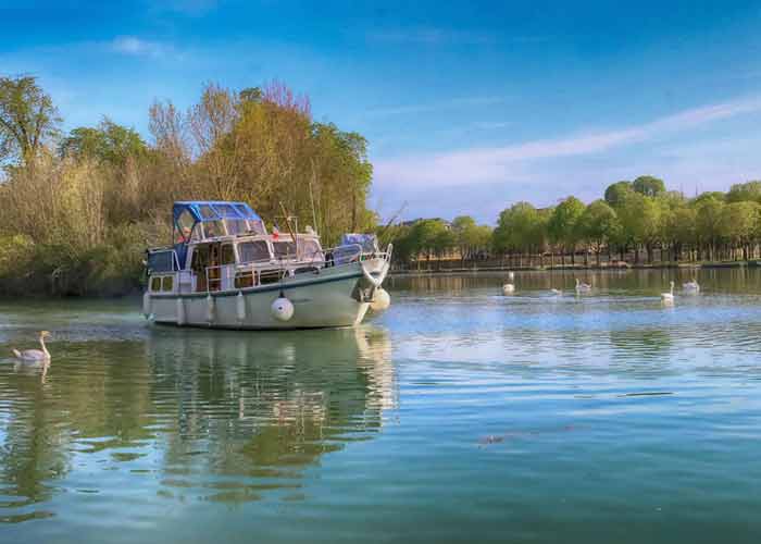 Croisière paisible en bateau sur la Marne en Seine-et-Marne, entourée
de cygnes et de nature verdoyante
