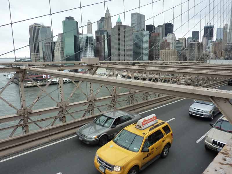 Vue sur Manhattan et sur les voitures qui traversent le pont le pont de Brooklyn depuis le brooklyn bridge